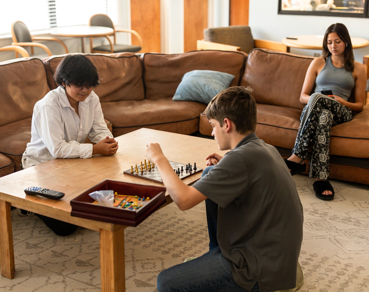 Students playing a board game together in a lounge.