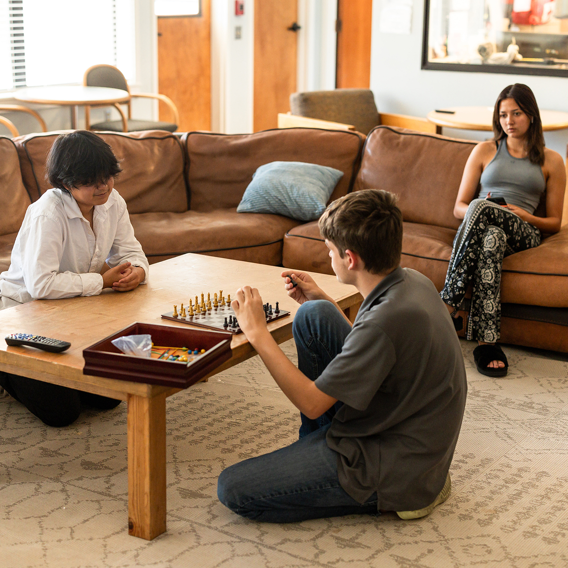 Students playing a board game in a lounge.